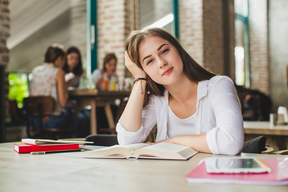 Charming girl student posting with textbook